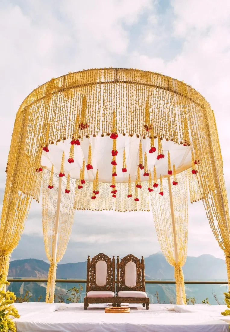 Golden floral destination wedding mandap overlooking the mountains
