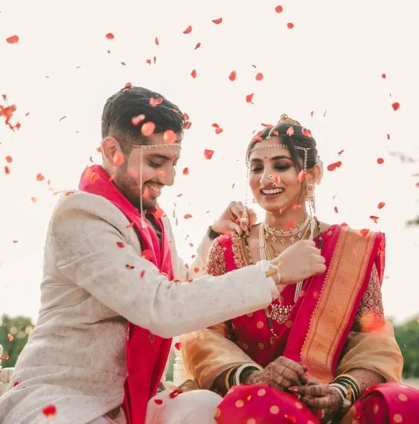 Couple laughing as petals fall during a ritual